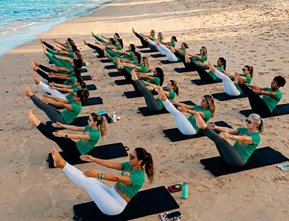 Aula coletiva de Pilates na praia durante o Encontro Nordestino